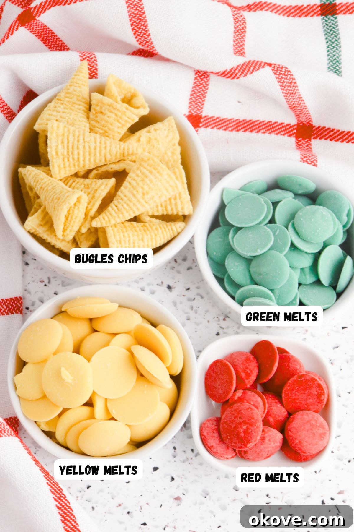 Elven Fanfare Headwear 3 Bowls of red, green, and yellow melting chocolates, along with a large bowl of cone-shaped Bugle corn chips, neatly arranged on a table for easy access.
