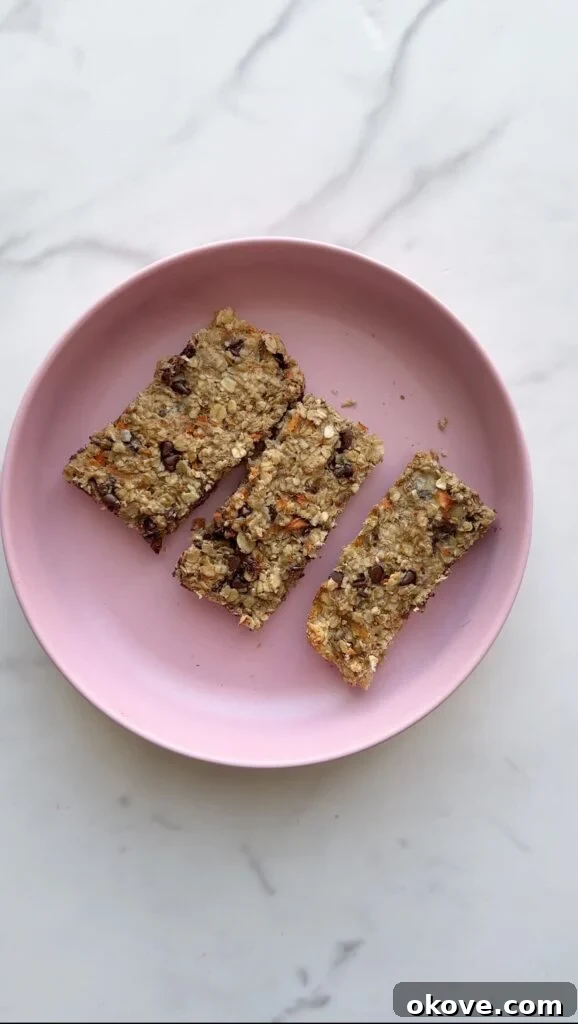 Golden Harvest Bars 2 Three healthy banana carrot bars stacked on a pink plate, perfect for toddler snacks or a quick breakfast.