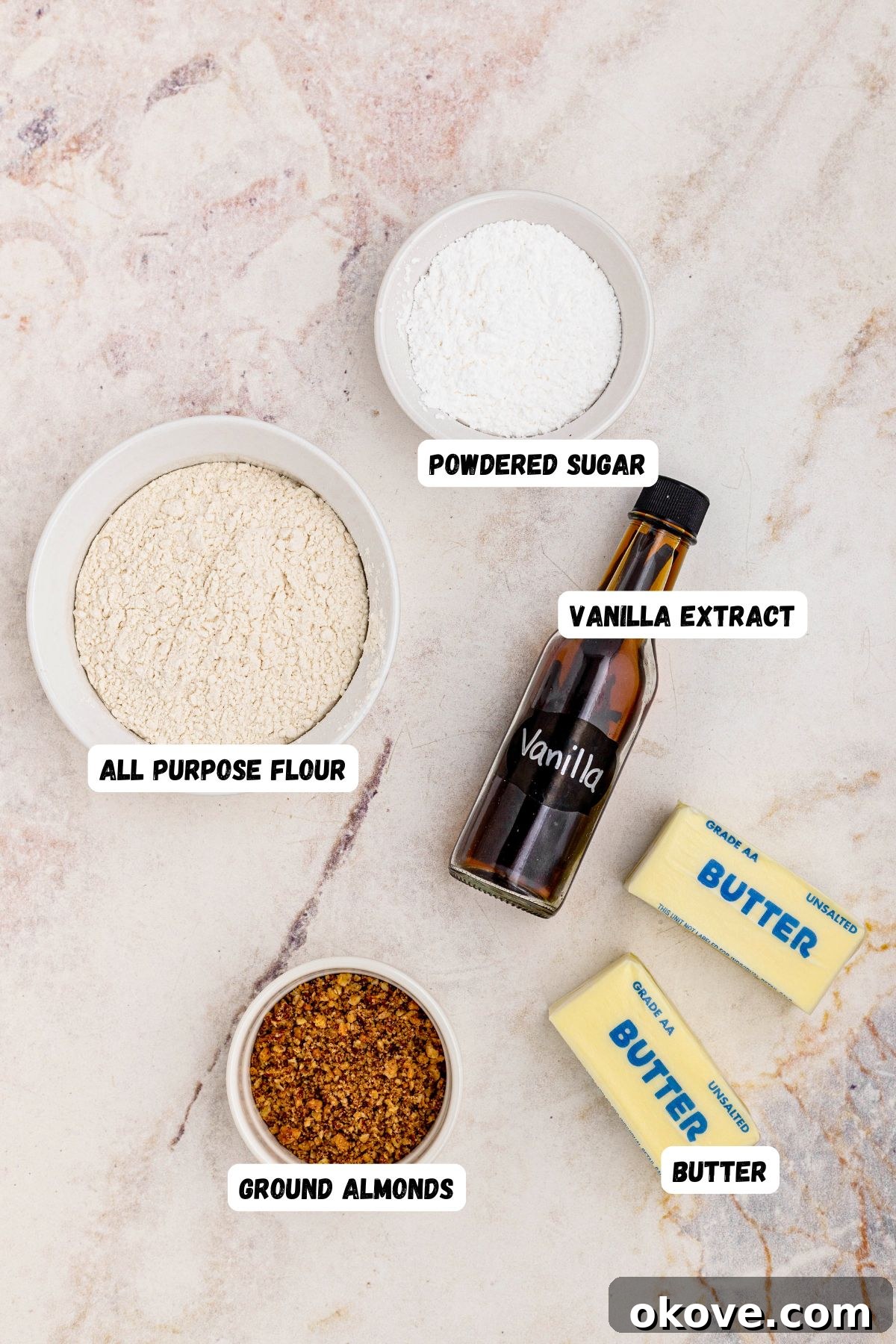 Powdered Cloud Kisses 3 Ingredients measured onto marble counter and labeled for making snowball cookies.