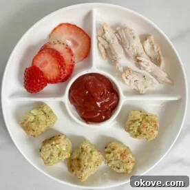 Perfectly golden brown zucchini parmesan tots artfully arranged on a white plate, ready to be enjoyed.