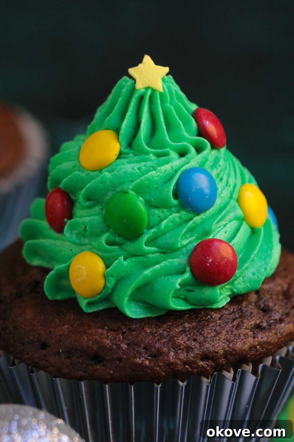 Edible Christmas Trees 6 Mini candies pressed into green buttercream to look like lights and ornaments on a tree cupcake.