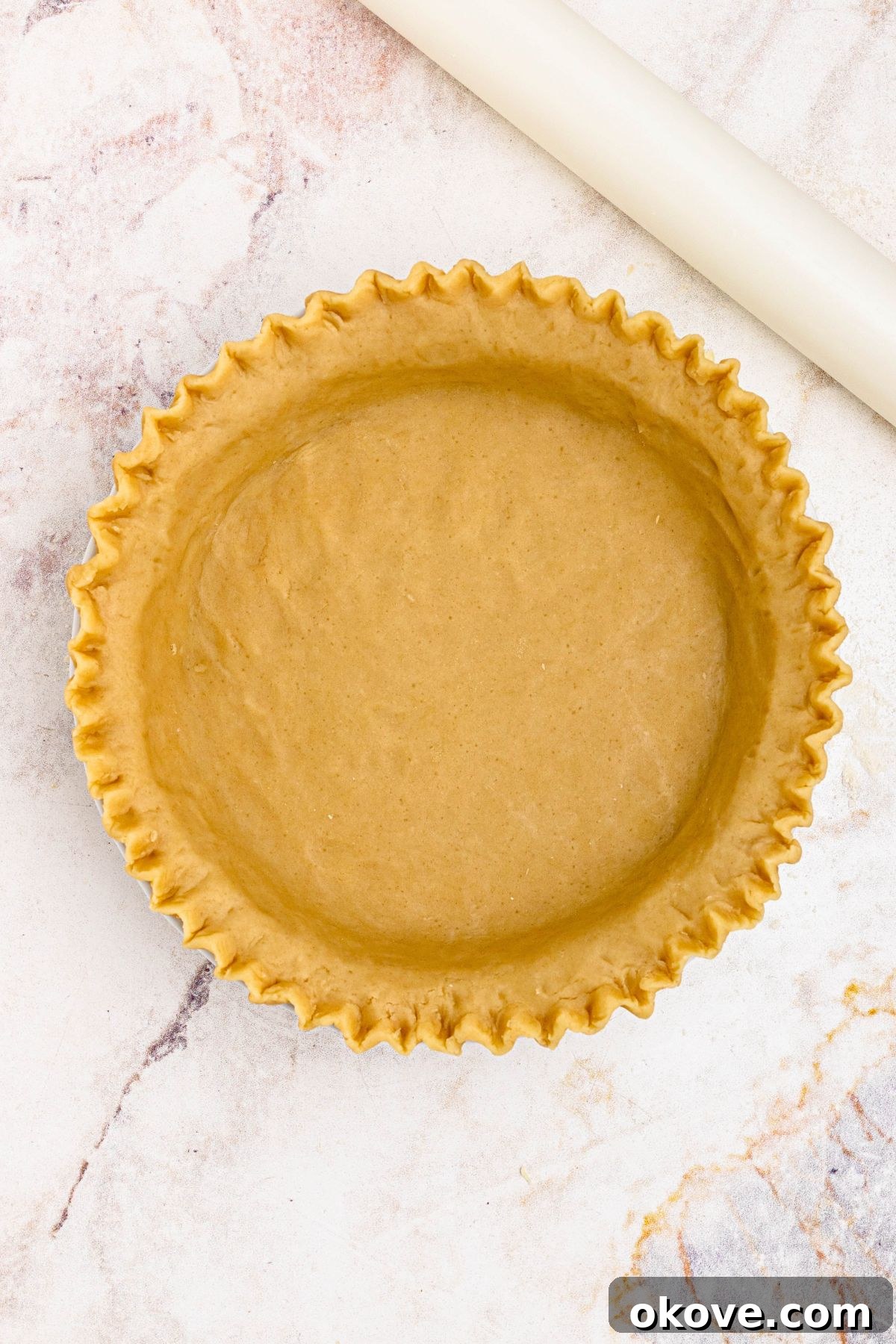 Golden pie crust, rolled into pie plate, with edges fluted.