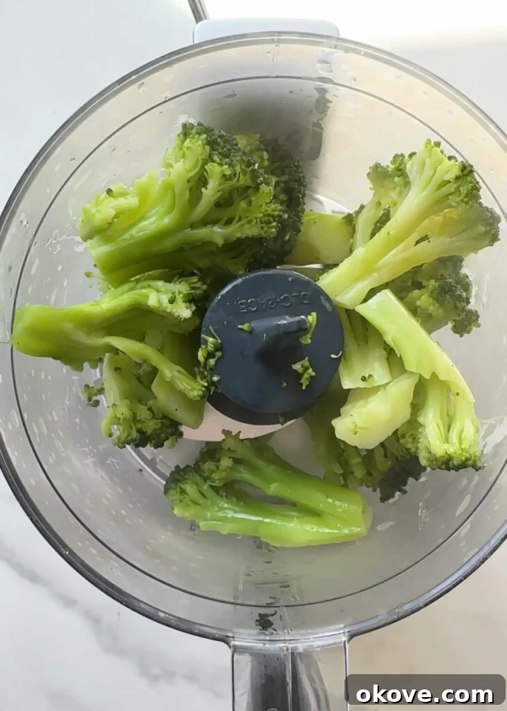 Creamy Broccoli Pasta 3 Steamed broccoli, cream cheese, garlic powder, and pasta water in a blender, ready to be processed into sauce.