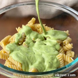 Creamy Broccoli Pasta 6 Broccoli pasta sauce being poured onto a bowl of pasta.