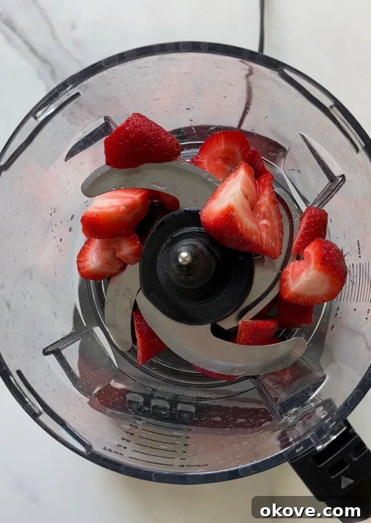 Fresh strawberries and raspberries in a bowl, ready for blending.
