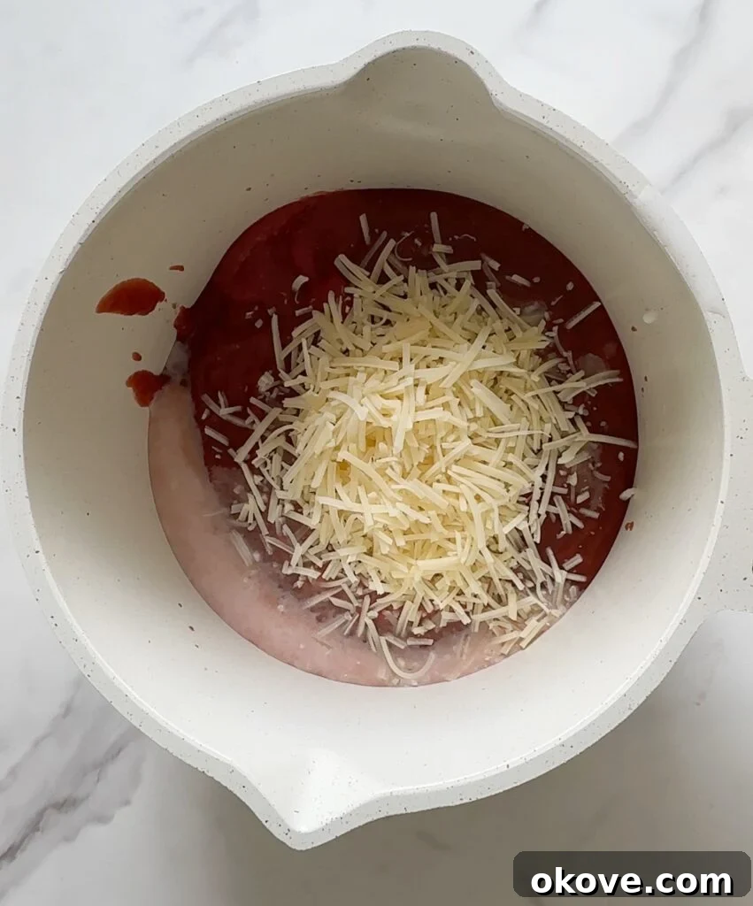 Various ingredients for spaghetti-o's laid out, including tomato sauce, milk, butter, and cheese in separate bowls.