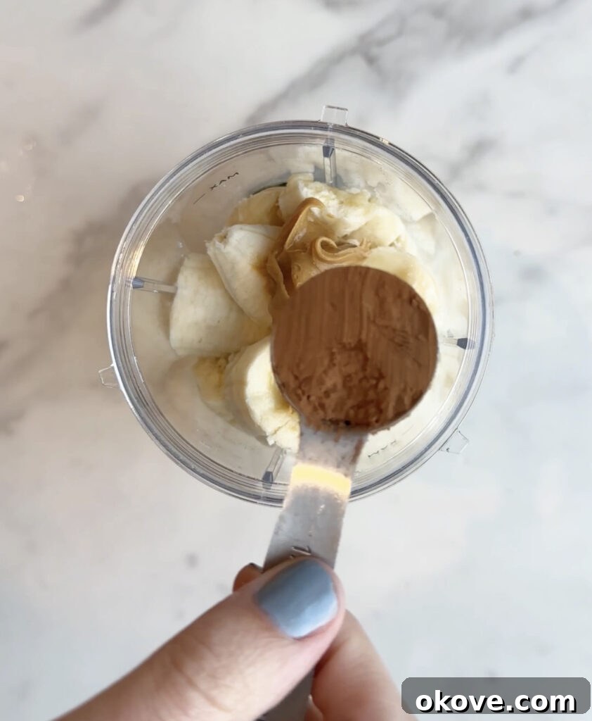 Guilt-Free Fudge Pops 6 Creamy nut butter being scooped, adding healthy fats and a smooth texture to the fudgesicle blend.