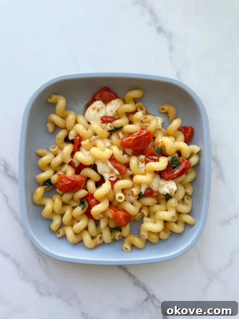Warm Caprese Pasta Bake 2 Baked caprese pasta on a blue plate