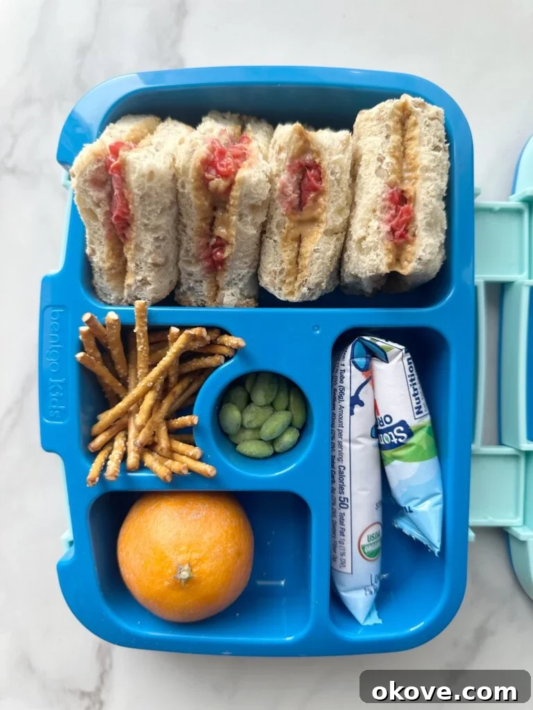 Lunchbox Magic for Toddlers 2 A toddler lunchbox with a sandwich, pretzels, edamame, a clementine, and yogurt inside