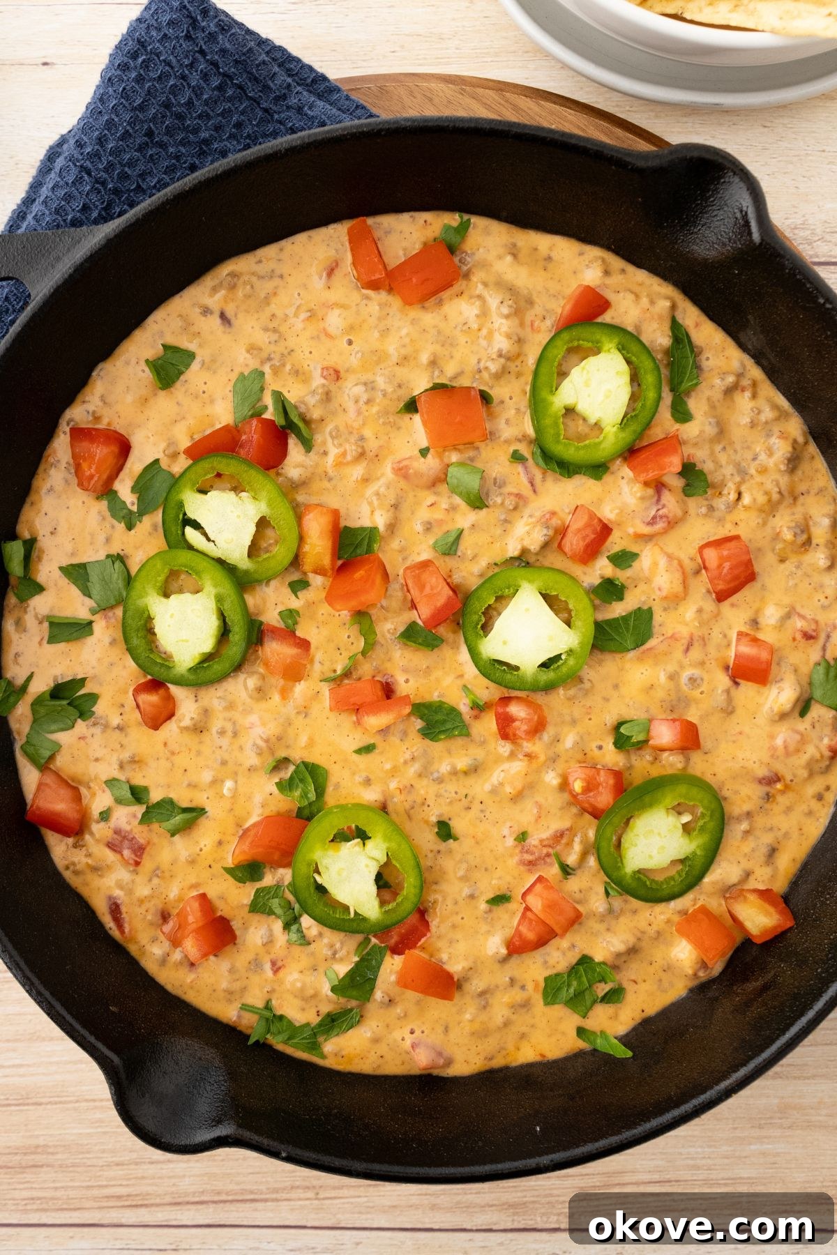 Rotel Fiesta Dip 6 Rotel dip in a black skillet topped with jalapenos and diced tomatoes.