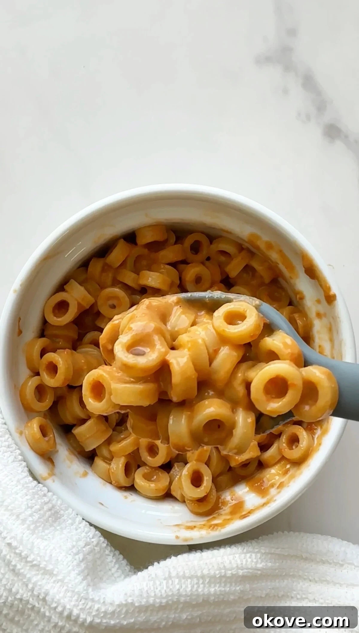 A spoonful of creamy veggie pasta with hidden spinach and tomatoes.