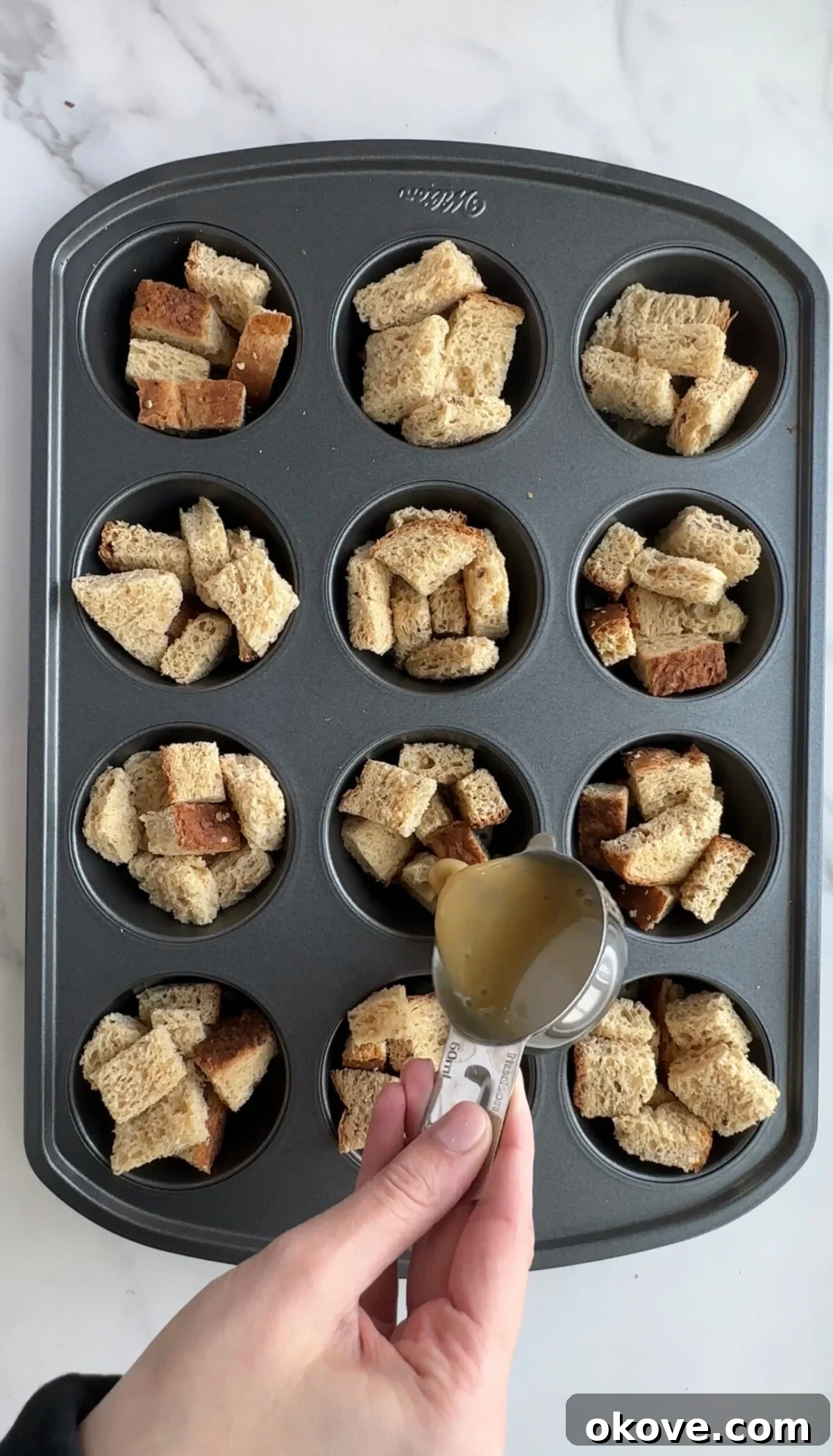 Baked French Toast Muffins 3 Pouring batter over pieces of bread in a muffin tin