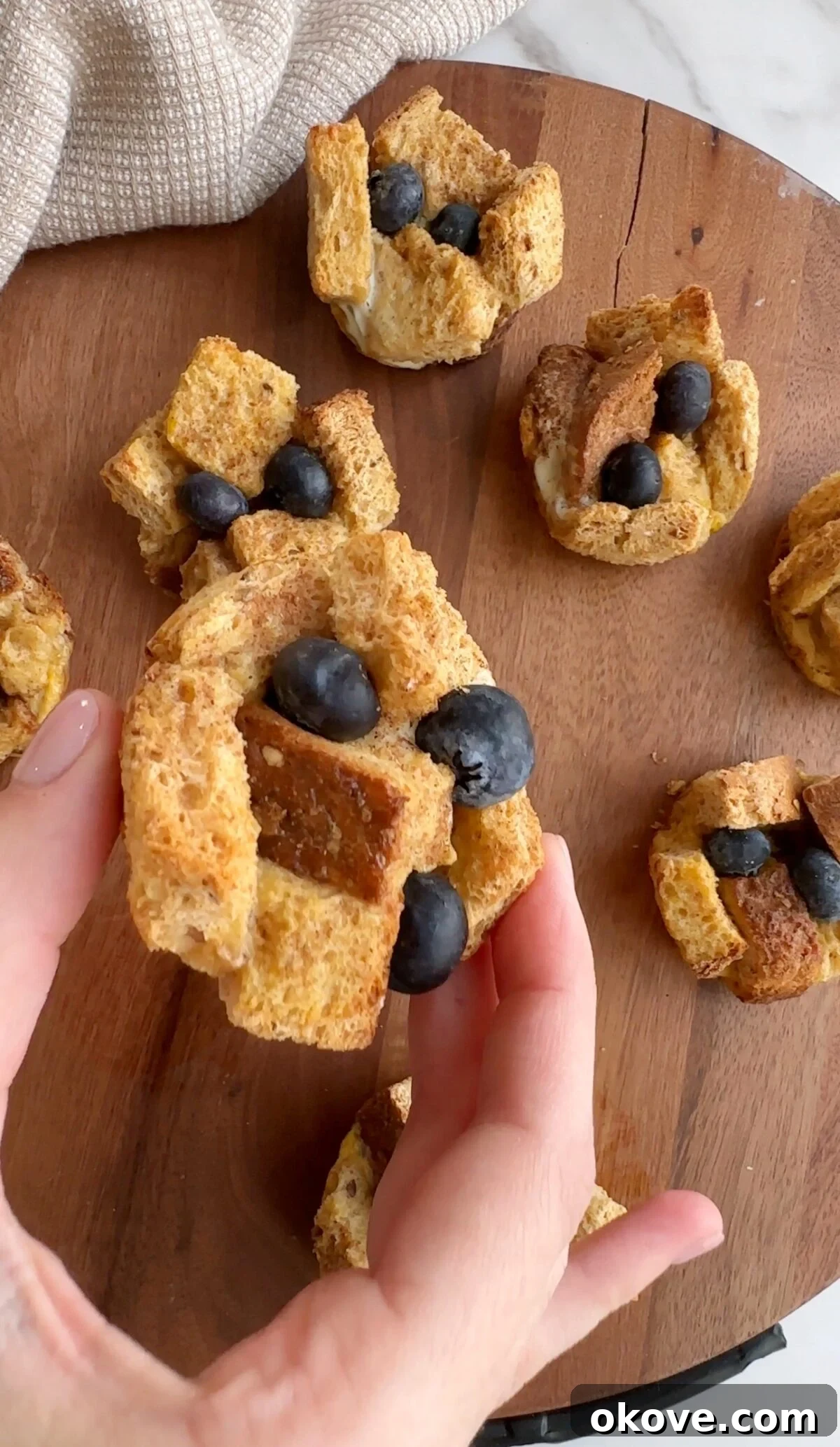 Baked French Toast Muffins 4 A hand holding up easy french toast cups