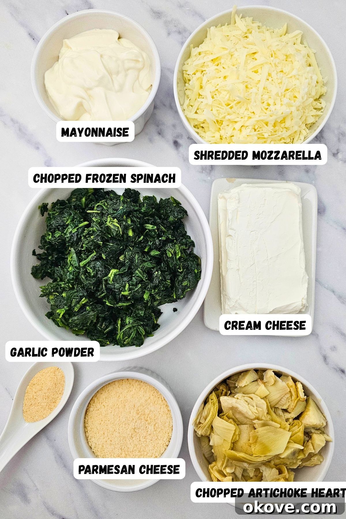 Creamy Spinach Artichoke Delight 3 All the measured ingredients for spinach artichoke dip laid out in small bowls and clearly labeled, ready for mixing.