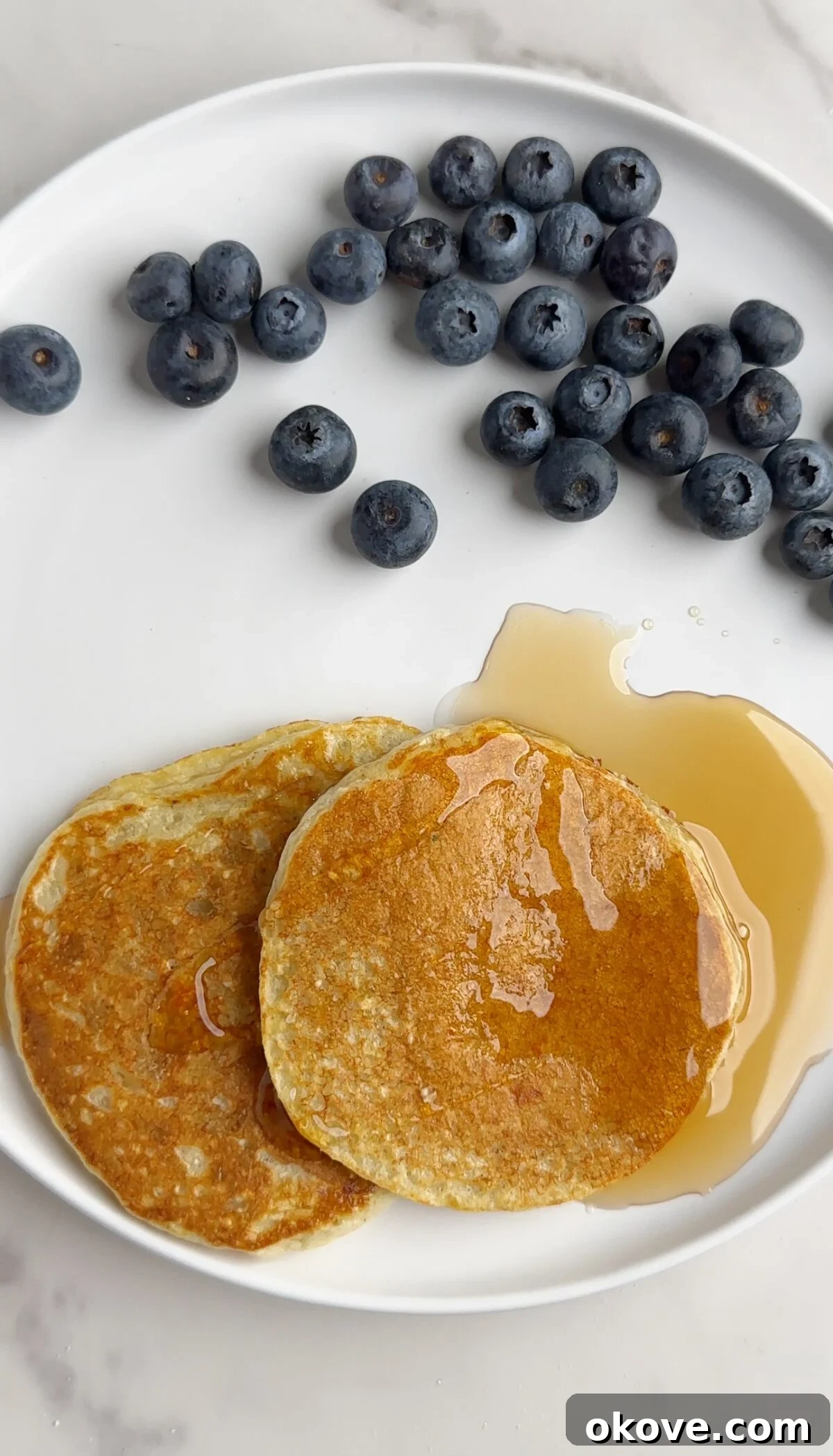 Delicious protein pancakes stacked high, topped with fresh blueberries and maple syrup, ready for a nutritious breakfast.