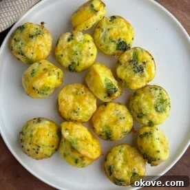 Yummy broccoli egg bites on a white plate, showcasing their golden texture and vibrant green broccoli pieces.