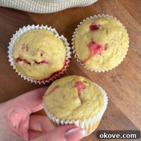 Irresistible Raspberry Muffins 3 A perfectly baked raspberry muffin, golden brown with visible raspberries, ready for a toddler.