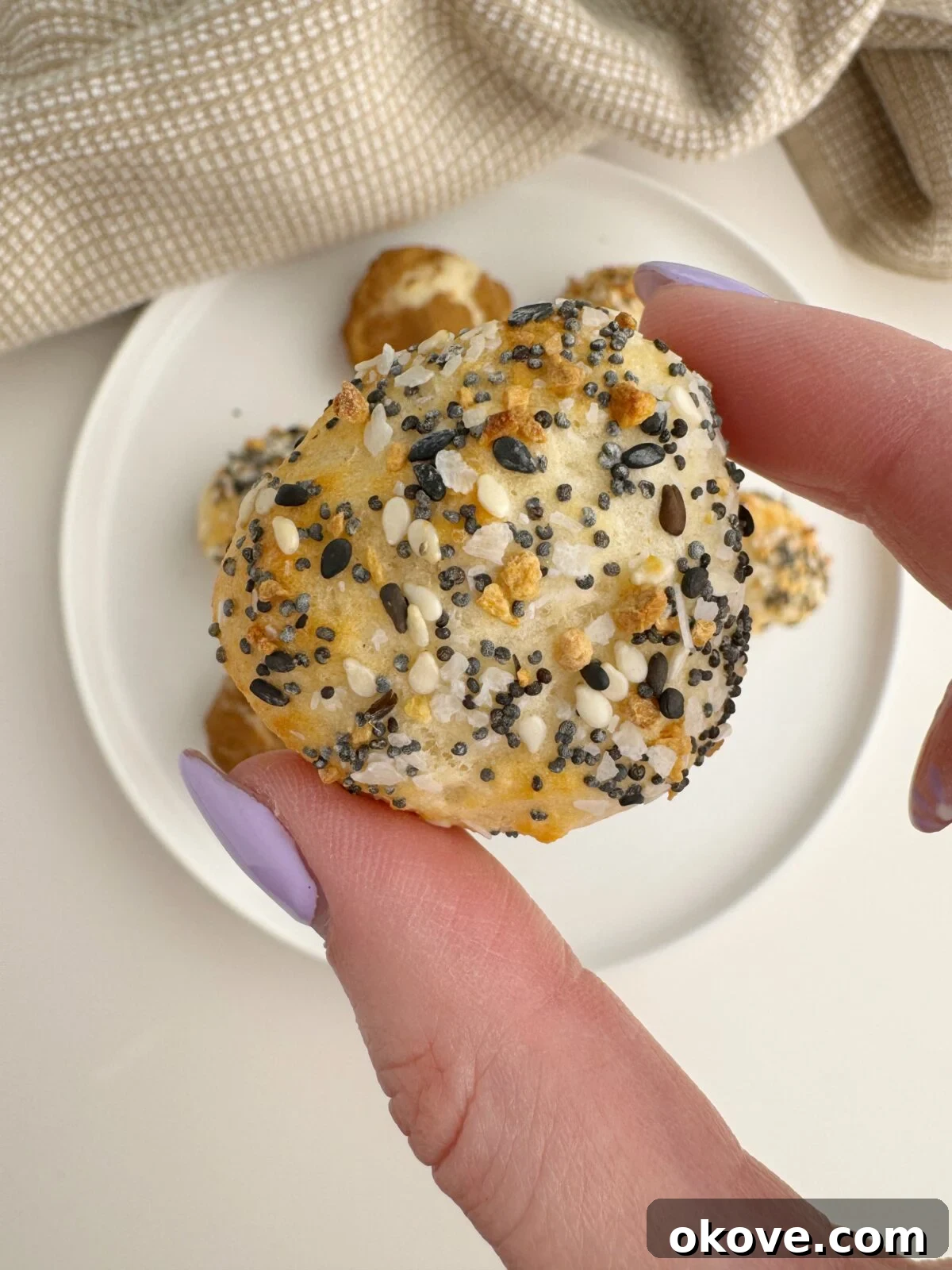 Bite-Sized Bagel Bliss 2 A hand holding up golden brown mini bagel bites, fresh from the air fryer