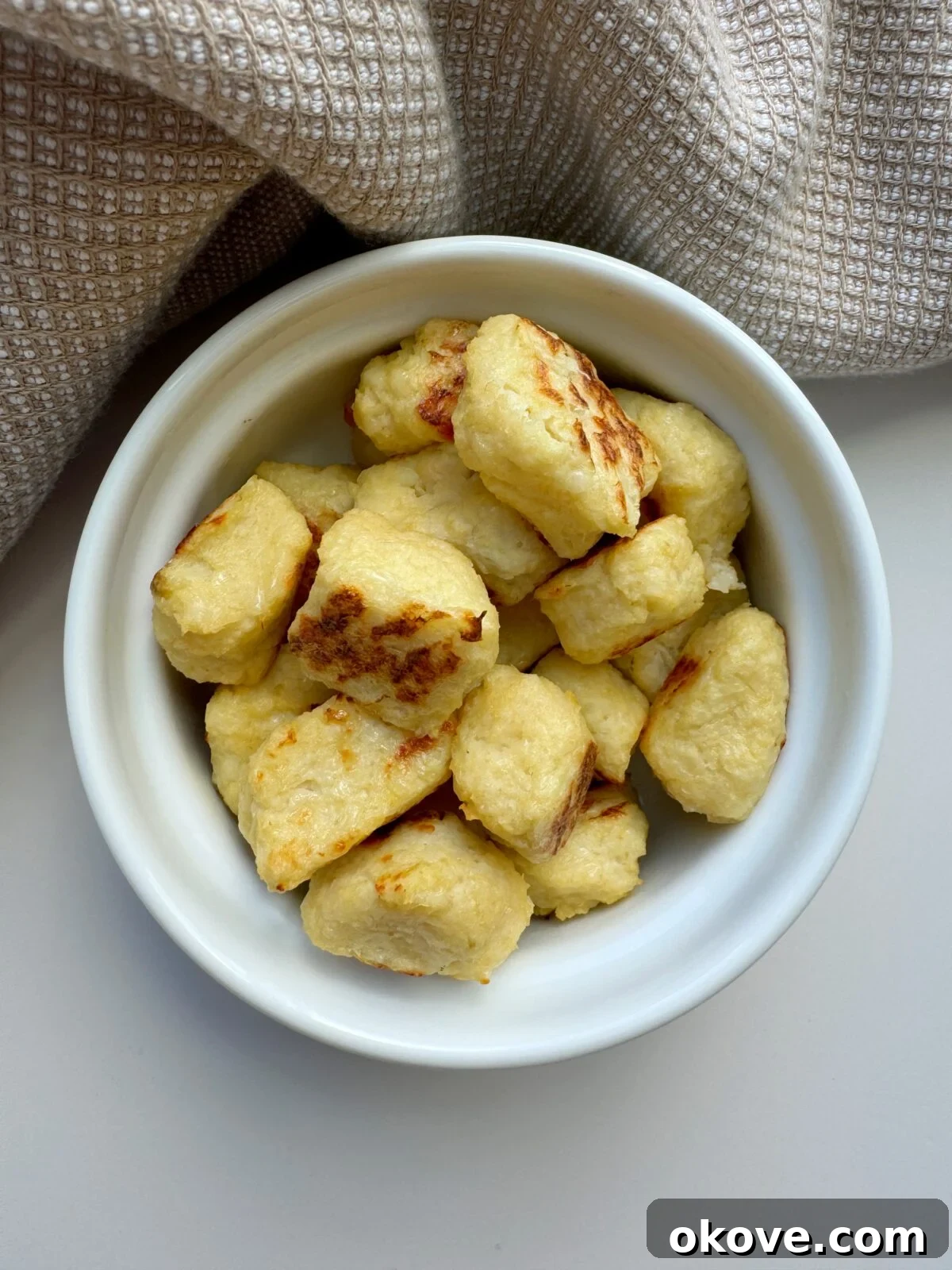 A vibrant bowl filled with golden, crispy cauliflower nuggets, ready to be enjoyed by toddlers and families.