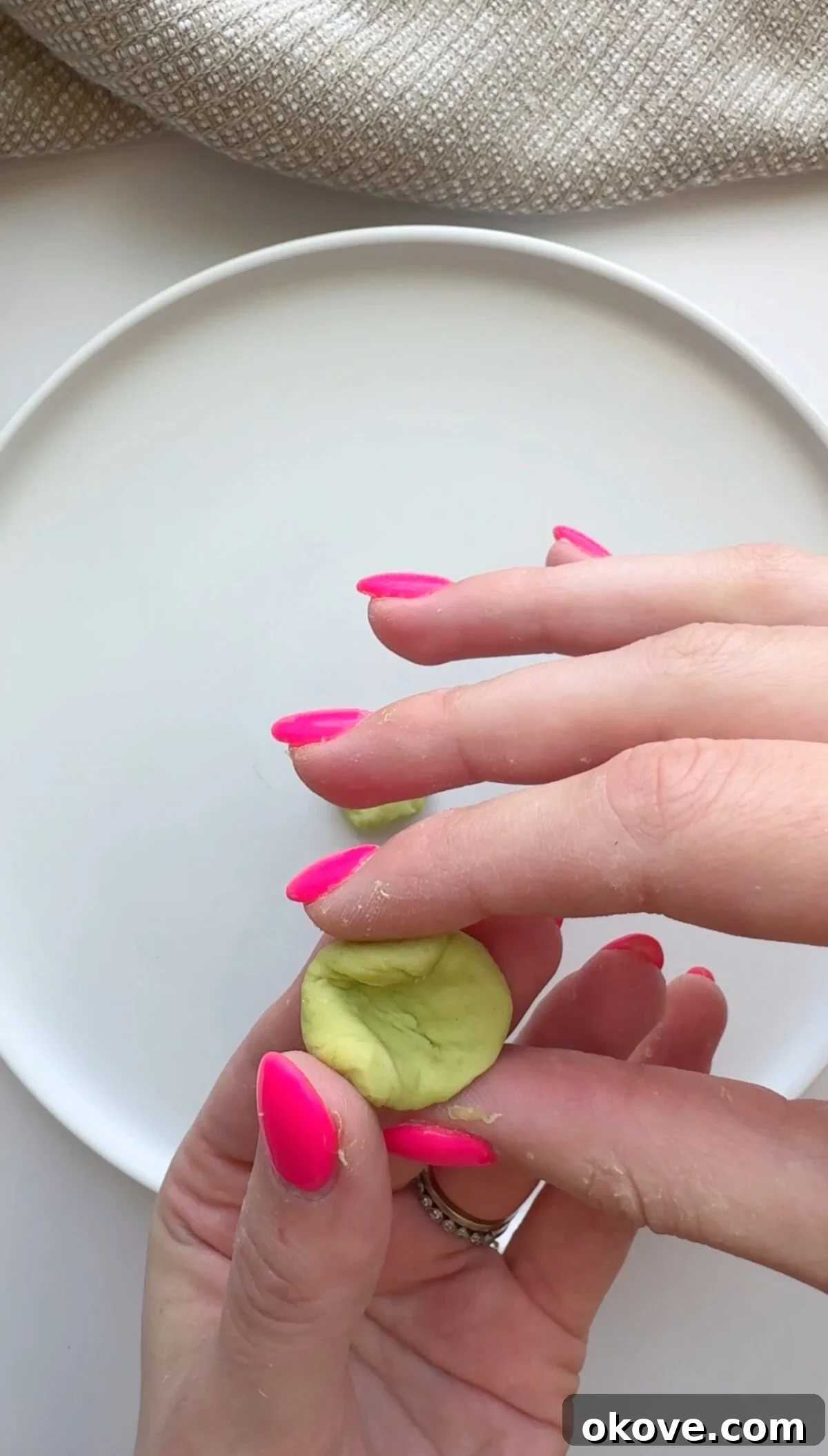 Emerald Avocado Pasta 3 Hands carefully shaping the avocadough pasta into small pieces over a pot of boiling water.
