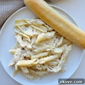 Olive Garden chicken pasta on a plate with a breadstick