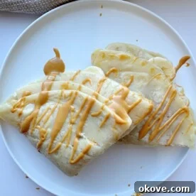 A close-up of a stack of freshly cooked banana crepes, ready for toppings.