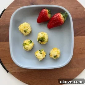 Easy Broccoli rice balls on a plate with two strawberries