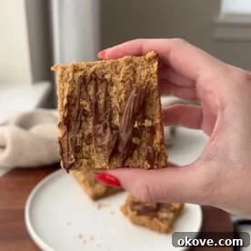 A hand holding up a healthy apple oat bar