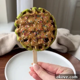A spinach waffle pop with peanut butter and sprinkles on top.