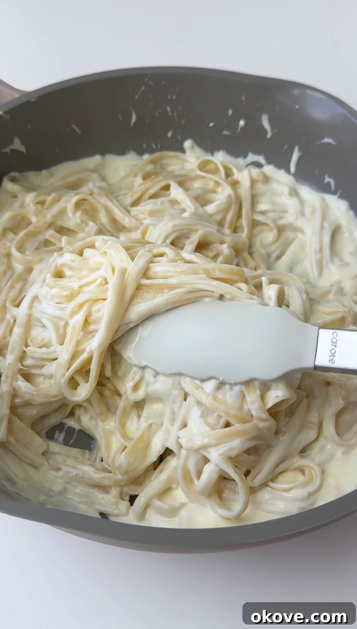 A bowl of creamy Alfredo pasta, perfectly coated in a rich white sauce, garnished with fresh parsley.