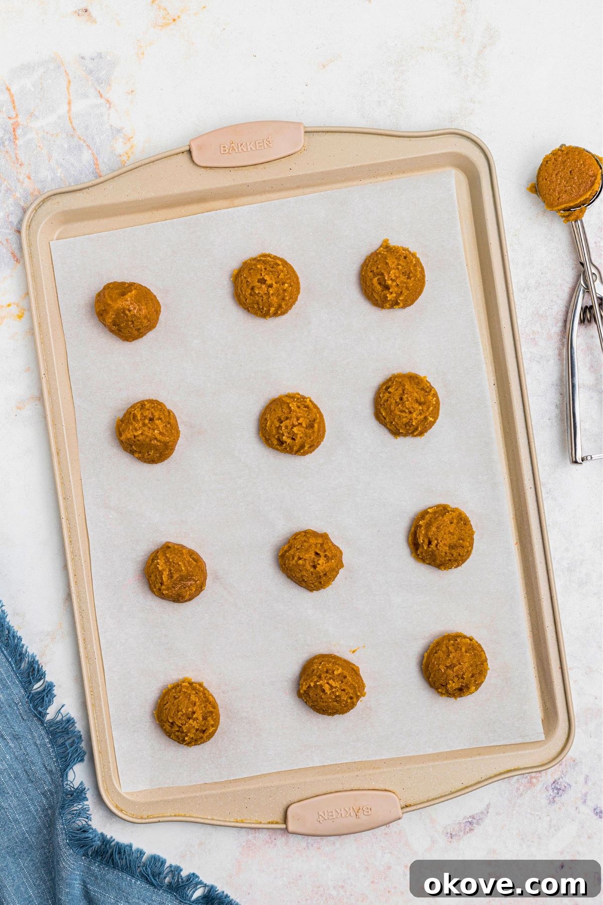 Effortless 3 Ingredient Peanut Butter Bliss 6 Scoops of cookie dough dropped onto baking sheet, lined with parchment paper, before baking.