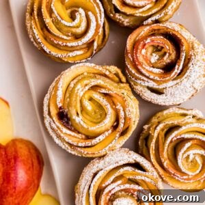 Apple roses on a white rectangle plate, then sprinkled with powdered sugar.
