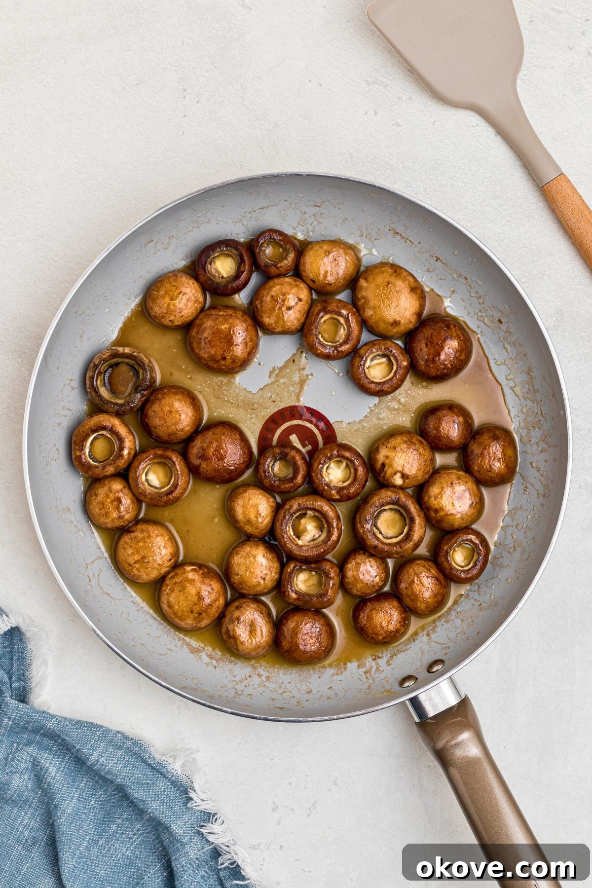 Mushrooms being sauteed in butter in a large saucepan. 