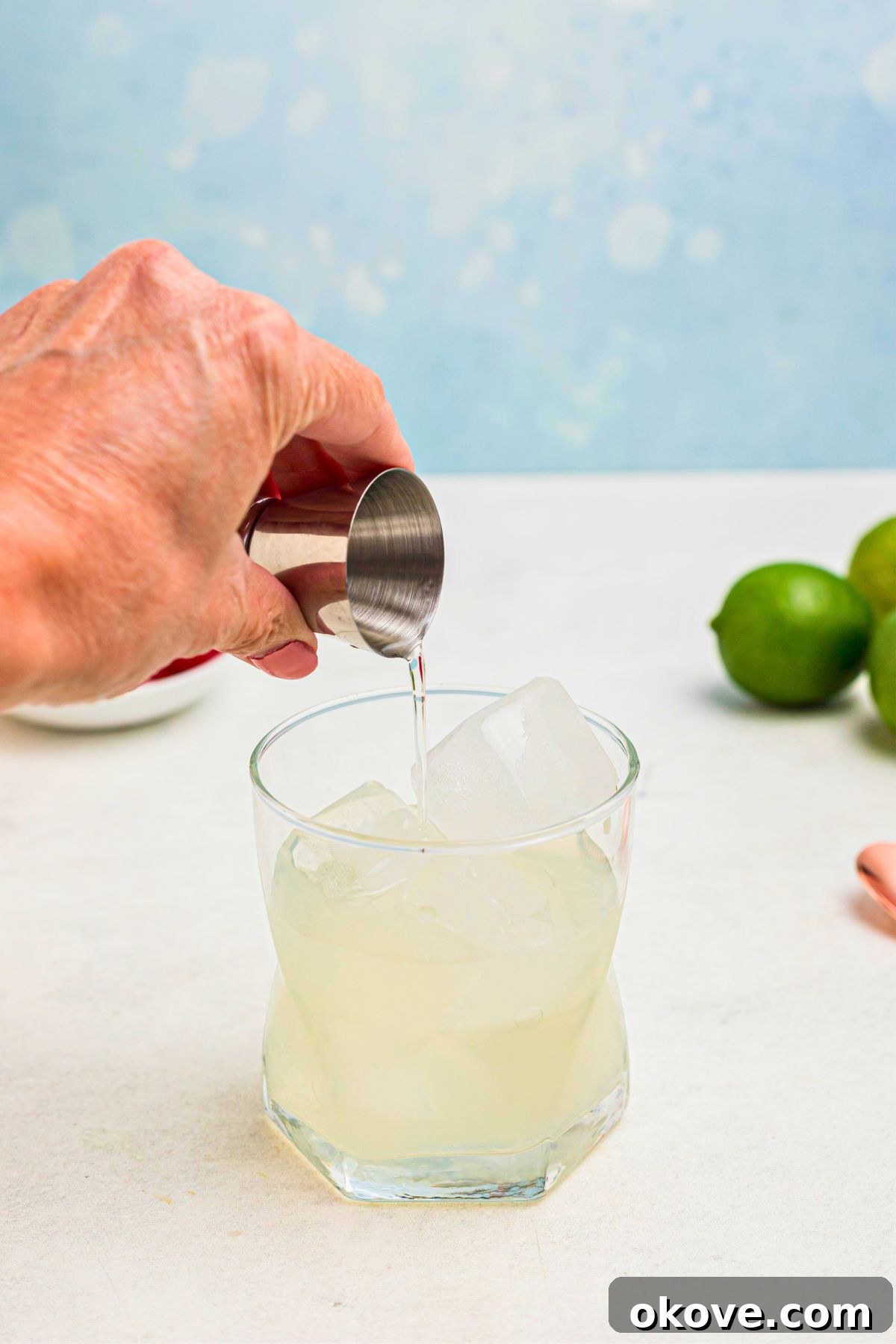 Mai Tai: Sip of the South Seas 4 Clear liquid being poured into a clear glass filled with crushed ice, a crucial first step for making a Mai Tai.
