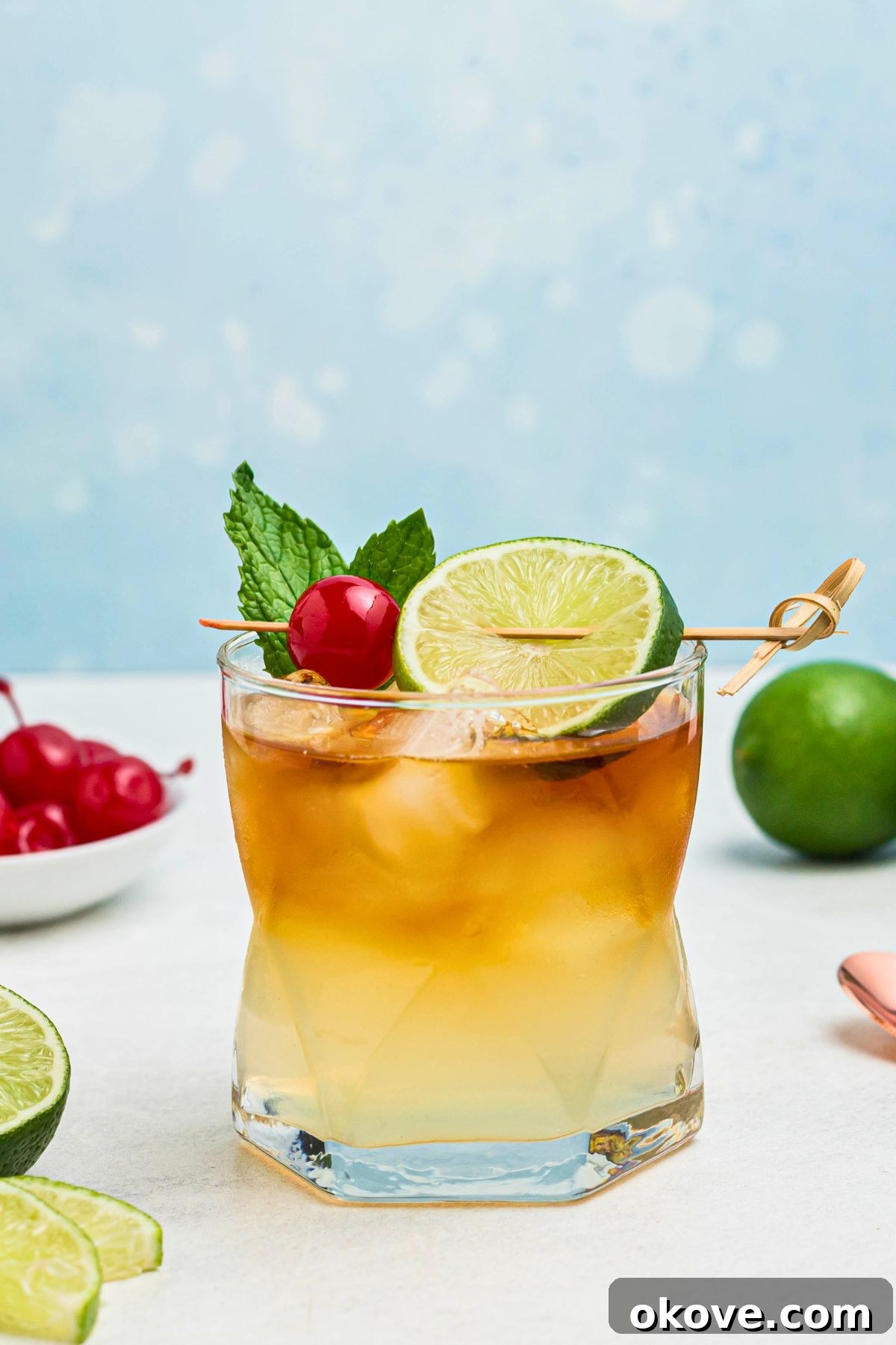 Mai Tai: Sip of the South Seas 7 A finished Mai Tai cocktail in a clear half glass, exquisitely garnished with a maraschino cherry and a vibrant lime slice, ready to be enjoyed.