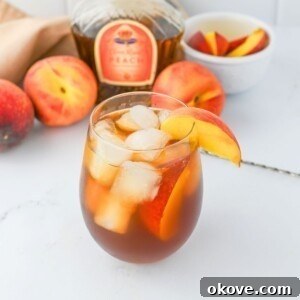 Fourth of July Recipes for a Memorable BBQ & Fireworks Night 20 Glass filled with ice, peach whiskey, and tea, on a white marble table.
