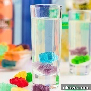 Fourth of July Recipes for a Memorable BBQ & Fireworks Night 24 Purple and blue gummy bear in a clear shot glass with a vodka mixture poured over them.