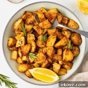 Fourth of July Recipes for a Memorable BBQ & Fireworks Night 34 Sliced potatoes in a white bowl with a spoonful lifting a serving out.