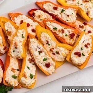 Fourth of July Recipes for a Memorable BBQ & Fireworks Night 5 Stuffed cream cheese peppers on a rectangle white plate.
