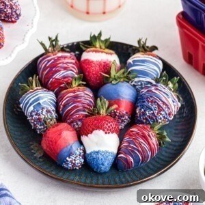Fourth of July Recipes for a Memorable BBQ & Fireworks Night 42 Red, white, and blue, dipped strawberries, placed side by side n a dark blue plate.