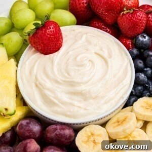 Fruit dip in a white bowl surrounded by fresh fruit.