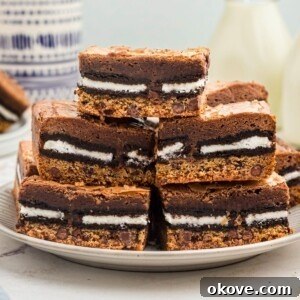 Stacked cookie brownies on a white plate.