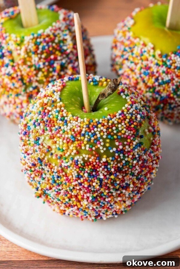 Green apples dipped in a coating and rolled in colorful sprinkles.