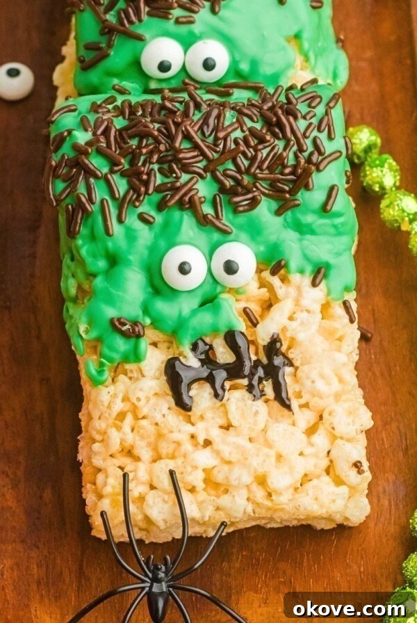 Spooky Halloween Chex Mix with Candy Corn and M&Ms 9 Decorated Frankenstein rice krispies treats on a wooden board.