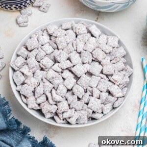 Puppy chow in a white bowl dusted with powdered sugar.