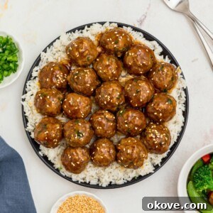 Teriyaki meatballs on a black plate.