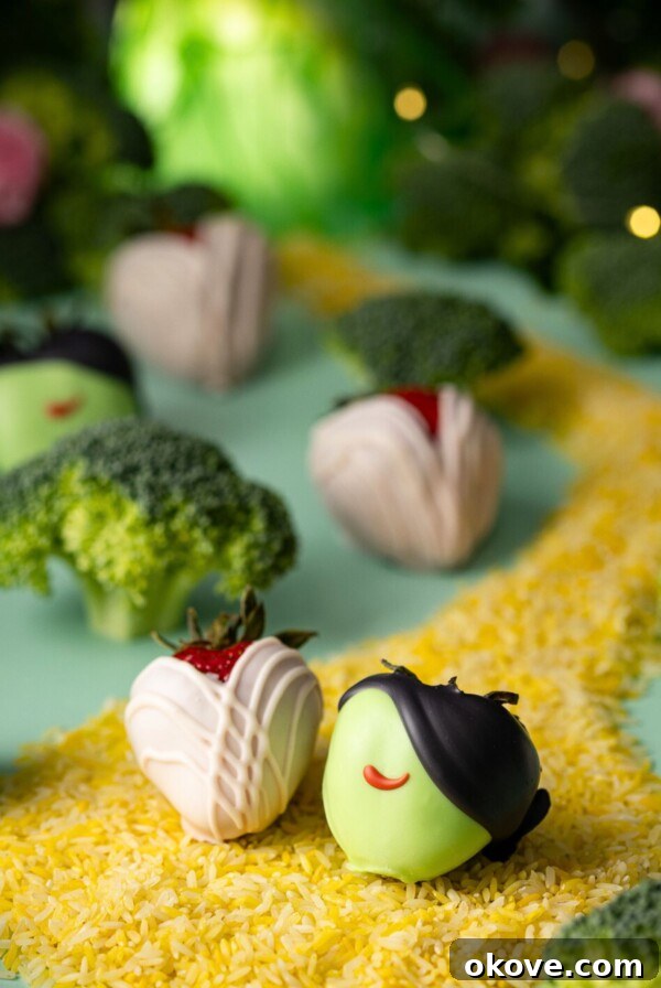 Wicked themed dipped strawberries on a green table with yellow rice for a road.