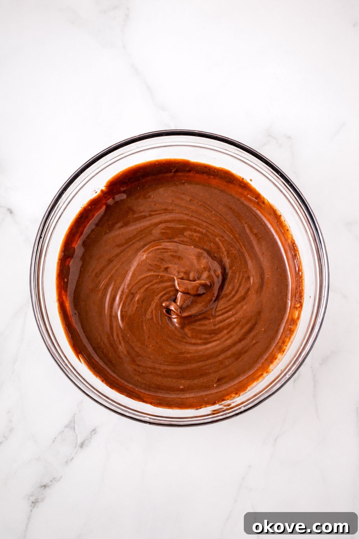 Large clear mixing bowl, filled with pudding mix and milk, mixed together until smooth and creamy.