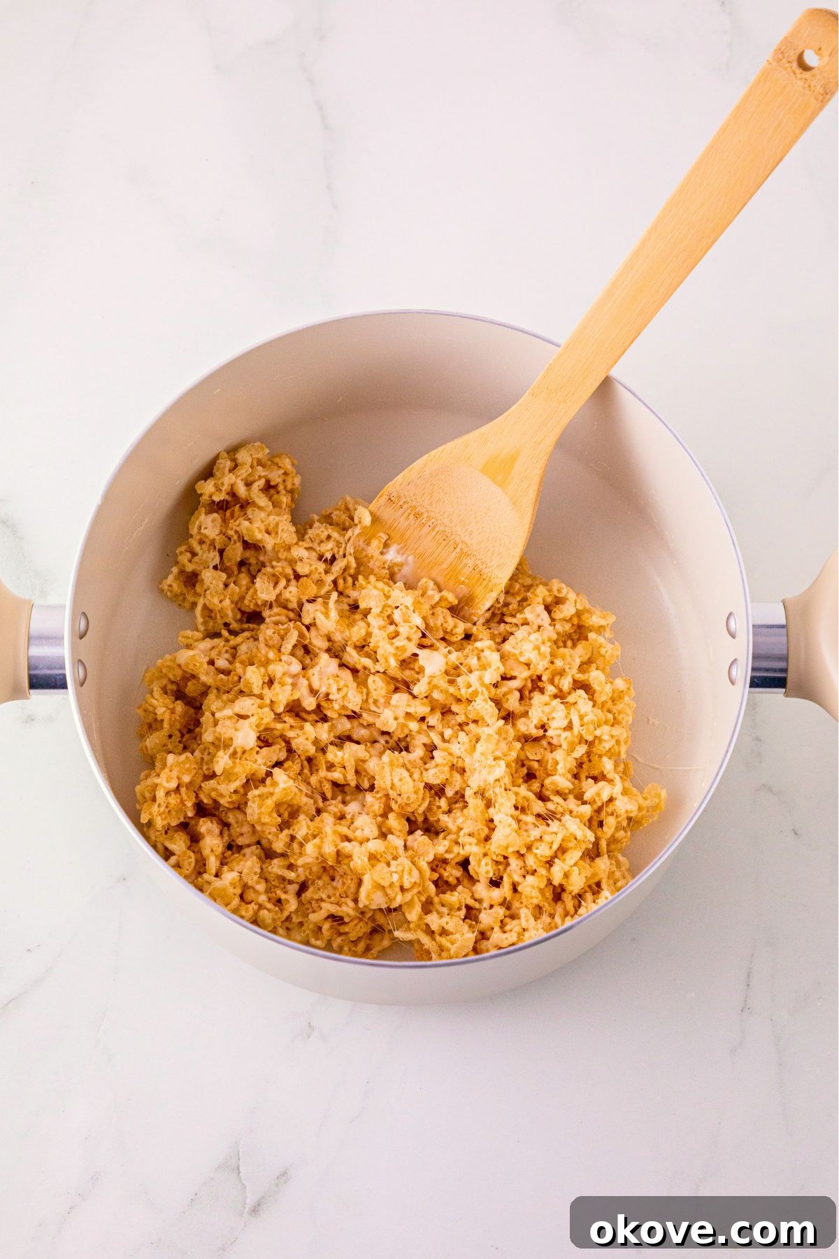 Rice Krispie cereal mixed together in a large saucepan.