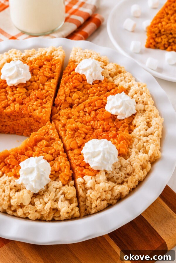 Whole pie of krispie treats in a pie plate, after cutting, on a marble table.